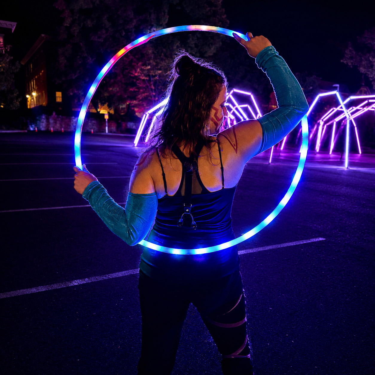 Performer with a glowing LED hoop at night